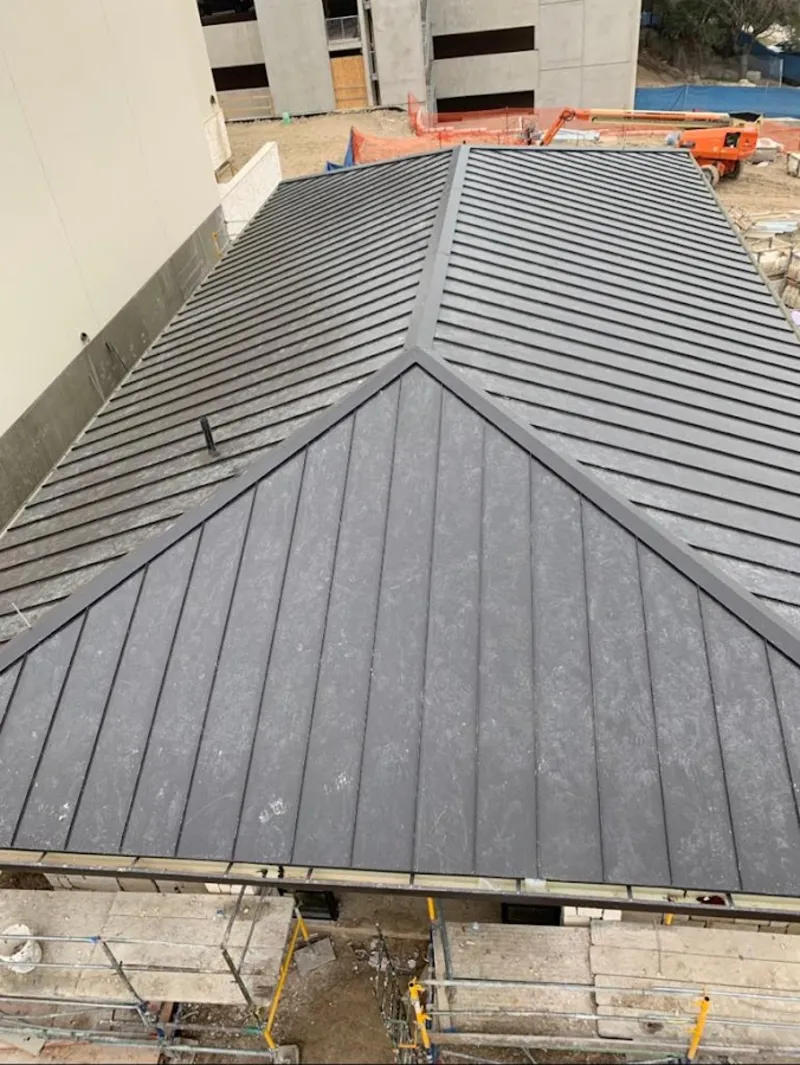 Commercial metal roof construction with crane equipment in Richmond